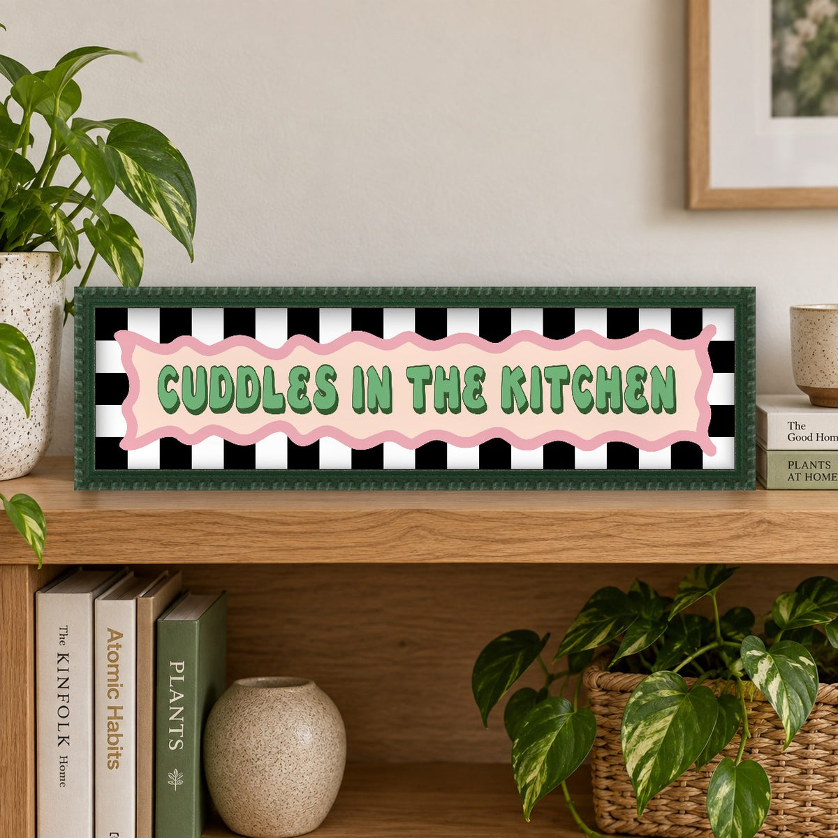 Cuddles In The Kitchen panoramic print in a forest green bobbin frame in a room setting